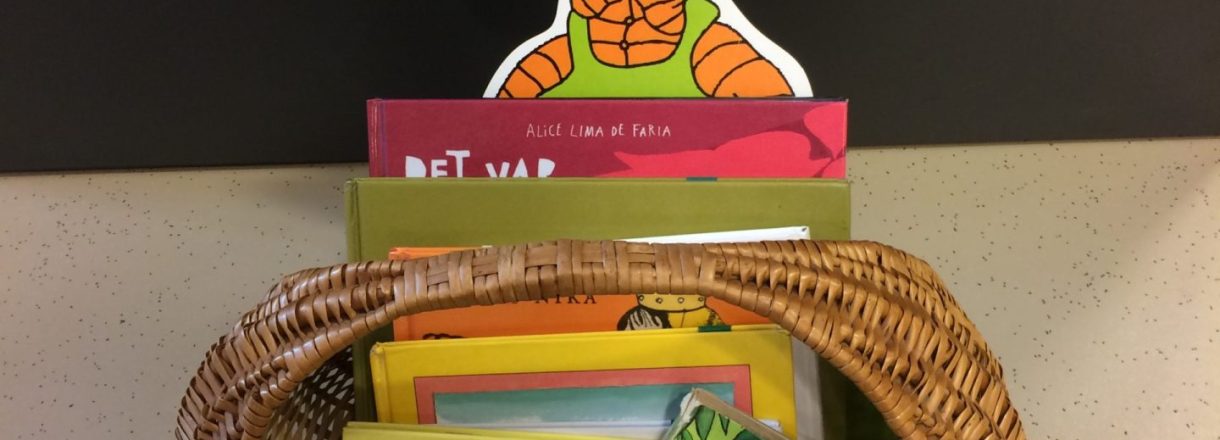 Korg med bøker og barnebokfigurane Ludde og Tassen