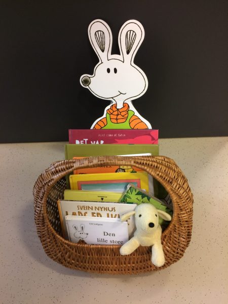 Korg med bøker og barnebokfigurane Ludde og Tassen