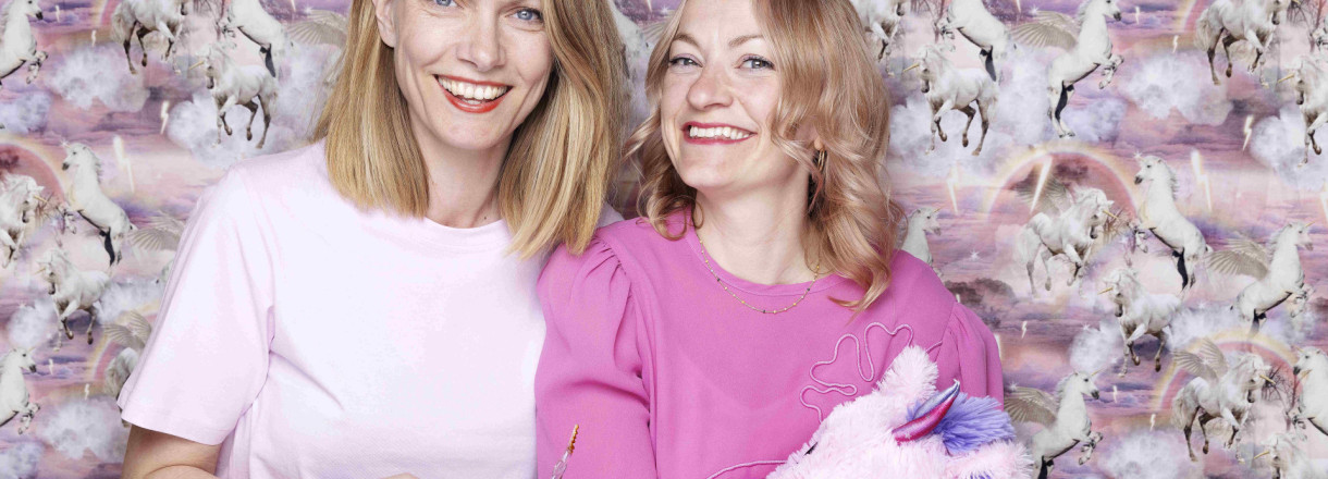 Foto av forfattarar Randi Fuglehaug og Anne Gunn Halvorsen. Anne Gunn Halvorsen held ein einhjørningsbamse.