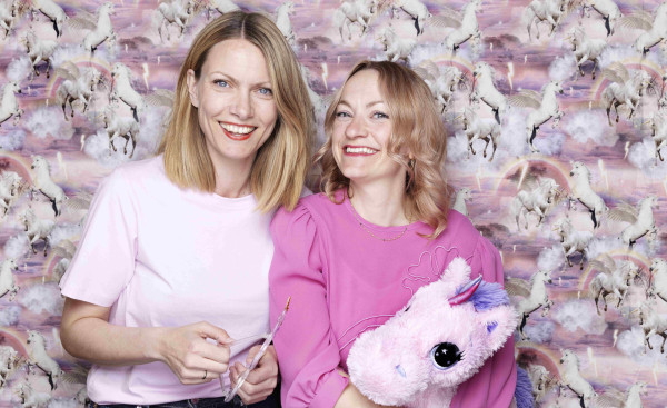 Foto av forfattarar Randi Fuglehaug og Anne Gunn Halvorsen. Anne Gunn Halvorsen held ein einhjørningsbamse.